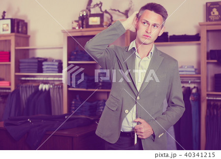 Shopper is trying on new emerald jacket Shopper is trying on new emerald jacket 40341215