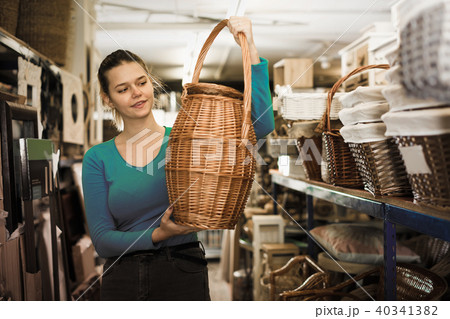 Young woman consumer holding wicker barrel Young woman consumer holding wicker barrel 40341382