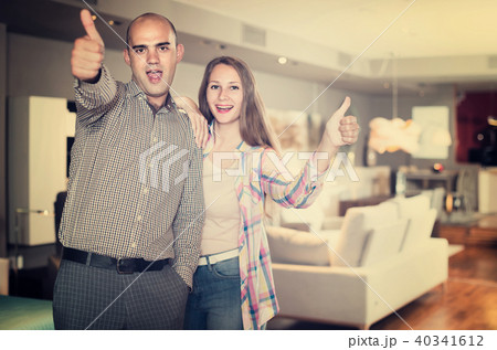 Portrait of man and woman with thumbs up in furniture salon Portrait of man and woman with thumbs up in furniture salon 40341612