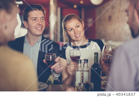 Elegant couple with friends enjoying evening meal at cozy restau Elegant couple with friends enjoying evening meal at cozy restau 40341837