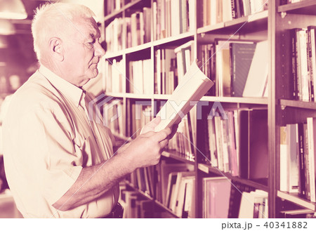 Old male is choosing book for reading in free time in bookstore. Old male is choosing book for reading in free time in bookstore. 40341882