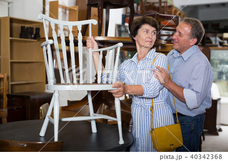 Mature couple is choosing the antique armchair Mature couple is choosing the antique armchair 40342368
