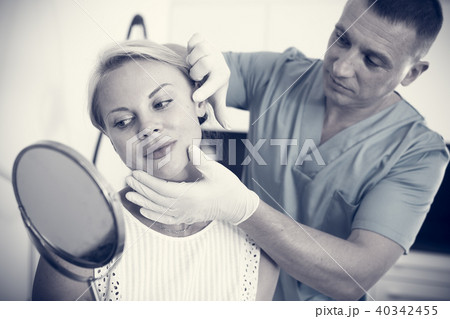 Doctor is examining woman patient behind mirror before the procedure 40342455