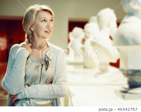 Adult female looking at artwork sculpture in the museum indoors Adult female looking at artwork sculpture in the museum indoors 40342767