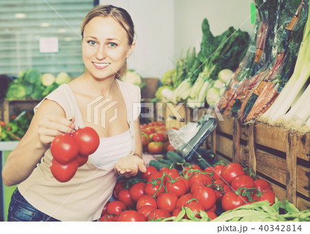Portrait of woman buying organic tomatoes in shop 40342814
