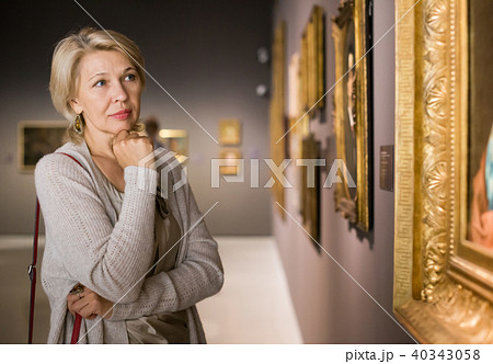 Mature woman in art museum near the painting Mature woman in art museum near the painting 40343058