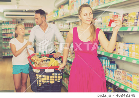 family of three choosing food in the grocery shop 40343249