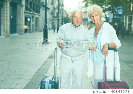 Senior woman and man traveling together looking for destination with city map Senior woman and man traveling together looking for destination with city map 40343578