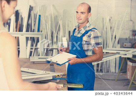 assembler of plastic windows with clipboard in hands talking to 40343644