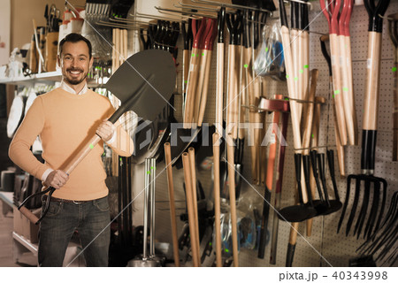 Positive guy deciding on best shovel 40343998