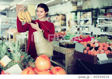 Portrait of brunette girl buying ripe bananas in supermarket 40344019