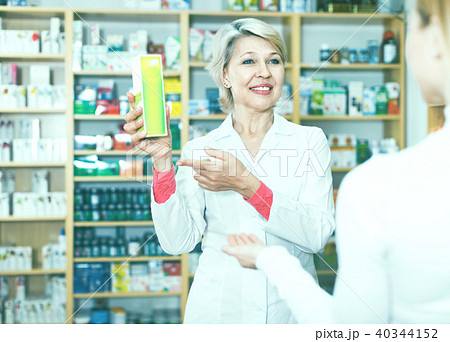 Mature female seller suggesting care products to young customer Mature female seller suggesting care products to young customer 40344152