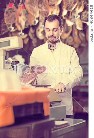 male seller weighing piece of meat in butcher’s shop male seller weighing piece of meat in butcher’s shop 40344419