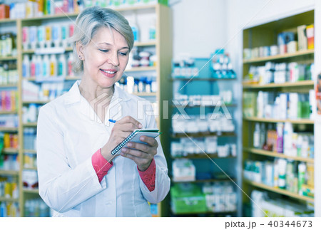 Female seller noting assortment in organic shop 40344673