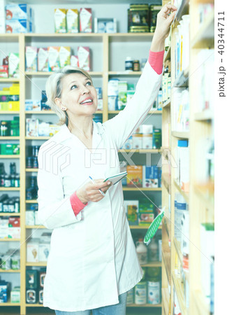 Female seller checking assortment of care products Female seller checking assortment of care products 40344711