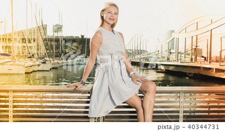woman sitting near the marina bay at bench woman sitting near the marina bay at bench 40344731