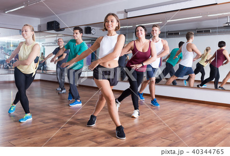 Cheerful people dancing zumba elements in dancing hall Cheerful people dancing zumba elements in dancing hall 40344765