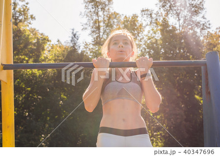 Fit woman doing pull-ups 40347696
