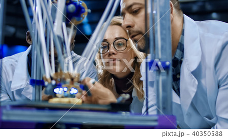 Researchers watching 3-D printing machine in process Researchers watching 3-D printing machine in process 40350588