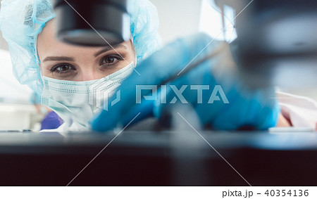 Doctor or lab technician adjusting needle to fertilize a human egg 40354136