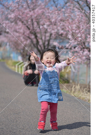 笑顔で走る2歳の女の子の写真素材