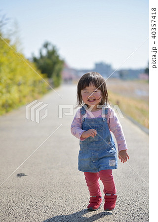 笑顔で走る2歳の女の子の写真素材