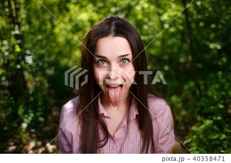 Portrait of young cute teasing woman showing tongue 40358471