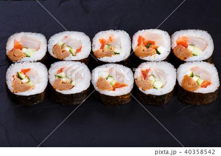Appetizing fresh maki sushi roll with omelet served on black sla Appetizing fresh maki sushi roll with omelet served on black sla 40358542