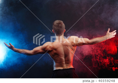Muscular handsome man bodybuilder with naked torso posing on smo 40359248