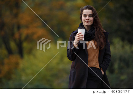 Young stylish woman wearing knitted sweater and coat walking in Young stylish woman wearing knitted sweater and coat walking in 40359477
