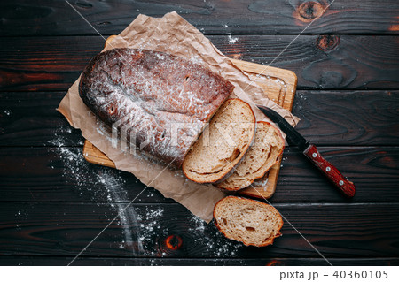 Freshly baked sliced rye bread on wooden cutting board, flat lay Freshly baked sliced rye bread on wooden cutting board, flat lay 40360105