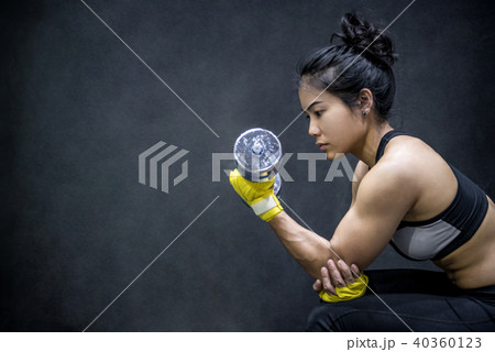 Young Asian woman lifting dumbbell, weight training Young Asian woman lifting dumbbell, weight training 40360123
