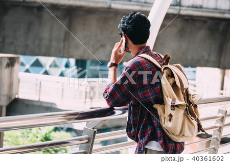 Casual Young asian man with backpack talking phone 40361602
