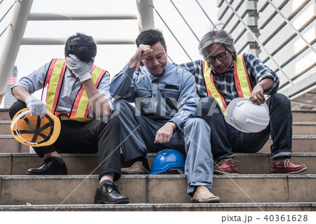 Unhappy engineer sitting at construction site 40361628