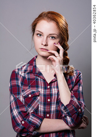 Young red-haired girl in a plaid shirt with finger 40362854