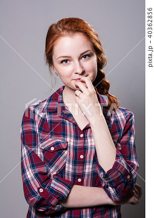 Young red-haired girl in a plaid shirt with finger 40362856