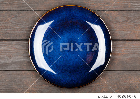 Blue plate on brown wooden table Blue plate on brown wooden table 40366046