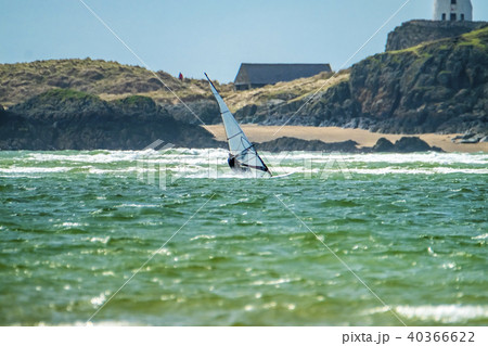 Wind surfer enjoys the beach at Newborough Warren with the Island of Llanddwyn in the background 40366622