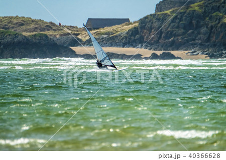 Wind surfer enjoys the beach at Newborough Warren with the Island of Llanddwyn in the background Wind surfer enjoys the beach at Newborough Warren with the Island of Llanddwyn in the background 40366628
