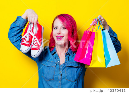 girl holding a shopping bags and red gumshoes girl holding a shopping bags and red gumshoes 40370411