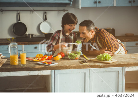 Child feeding daddy with healthy food 40372024