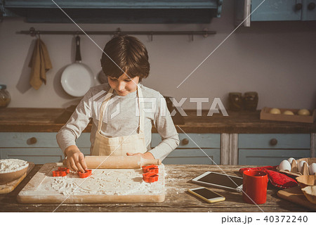 Little boy enjoying cooking of biscuits Little boy enjoying cooking of biscuits 40372240