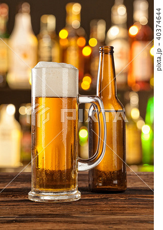 Glass of light beer with bar on background Glass of light beer with bar on background 40374644