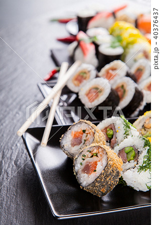Delicious sushi pieces served on black stone Delicious sushi pieces served on black stone 40376437