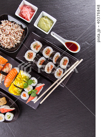 Delicious sushi pieces served on black stone Delicious sushi pieces served on black stone 40376848