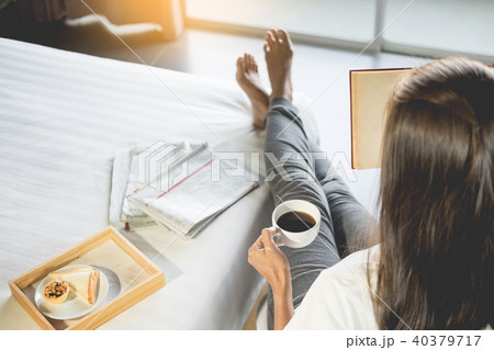 Woman reading book or newspaper and drinking coffee breakfast on 40379717