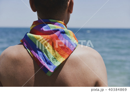man with a rainbow flag in front of the ocean man with a rainbow flag in front of the ocean 40384869