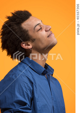 The happy business man standing and smiling against orange background. 40387366