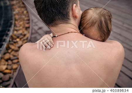Anonymous man embracing infant 40389634