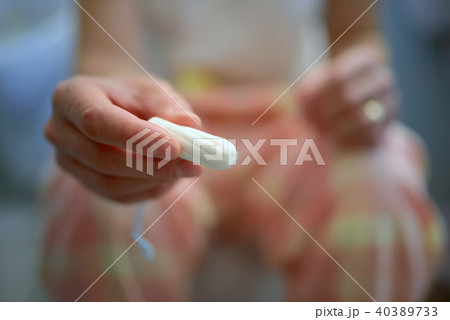 Woman holds a tampon Woman holds a tampon 40389733